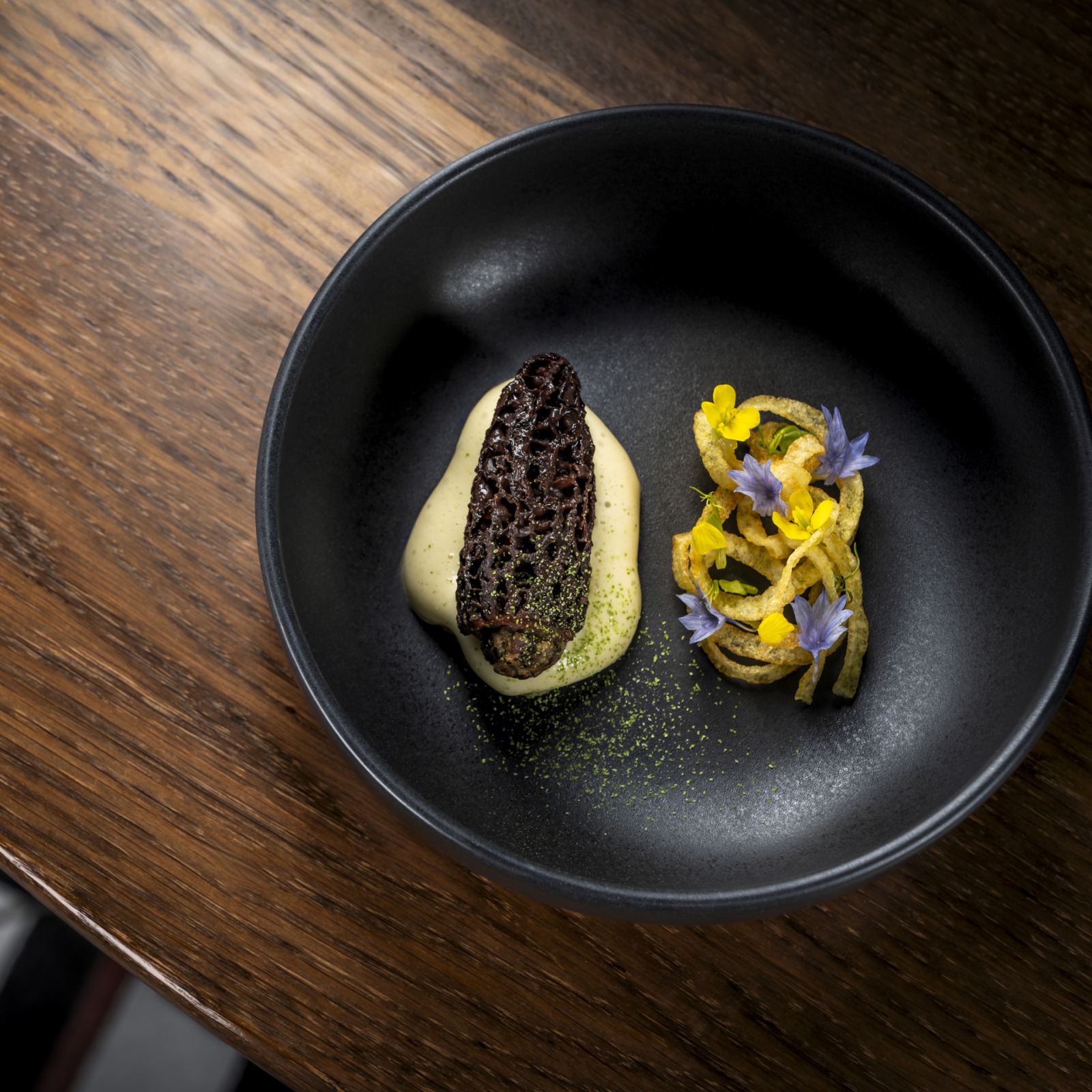 Gericht mit Morchel und essbaren Blüten im Fine-Dining-Restaurant